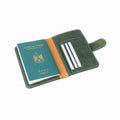 Green leather passport holder with a passport inside on a white background