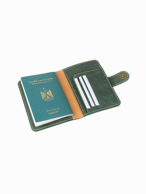 Green leather passport holder with a passport inside on a white background