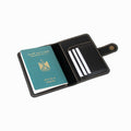 Black leather passport holder with a green passport inside on a white background