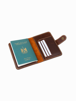 Brown leather passport holder with a green passport on a white background